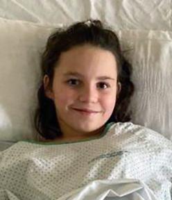 photo portrait de Téresita souriante sur son lit d'hôpital
